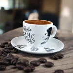 فنجان قهوة أم كلثوم بورسلين بتصميم كوبليه «دارت الأيام» – أبيض وأسود – شكل بيضاوي 90 مل