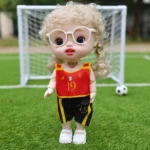 عروسة بناتي 23 سم بشعر كيرلي أشقر وعيون كبيرة مع نظارة – دمية أطفال بزي رياضي عصري وتصميم كيوت