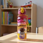 ⁦زجاجة مياه أطفال 1000 مل بتصميم Let's Go Space – ارتفاع 23.5 سم × قطر 7 سم بغطاء محكم وحزام يد⁩ - الصورة ⁦3⁩