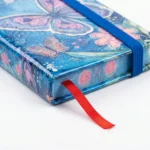 ⁦نوت بوك هارد كوفر صغيرة تصميم فراشات ملونة مقاس 10.5×7.5 سم برباط مطاطي⁩ - الصورة ⁦3⁩